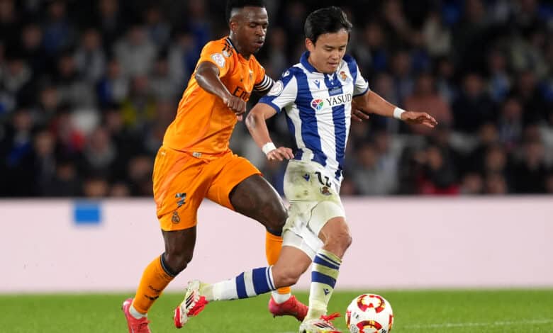 Vinicius Junior of Real Madrid battles for possession with Takefusa Kubo of Real Sociedad during the Copa del Rey Semi Final match