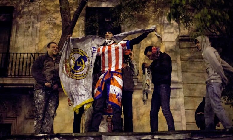 MADRID, SPAIN - MAY 17: Atletico Madrid supporters tears a Real Madrid flag to pieces after they won the Copa del Rey Final game between Real Madrid and Atletico de Madrid at Neptuno Square on May 17, 2013 in Madrid, Spain. Atletico's last victory over Real Madrid was in 1999 and it has been 21 years since the last Madrid derby for a Copa del Rey Final.