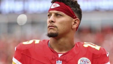 KANSAS CITY, MISSOURI - SEPTEMBER 14: Patrick Mahomes #15 of the Kansas City Chiefs stands on the sideline during the national anthem prior to an NFL football game against the Philadelphia Eagles at GEHA Field at Arrowhead Stadium on September 14, 2025 in Kansas City, Missouri.